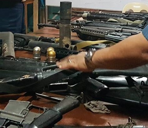 assorted high powered guns presented on the table in the room