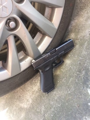 glock 17 besides a car wheel side view on the floor