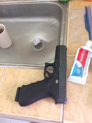 glock 17 g4 and magazine on kitchen sink beside toothpaste side view