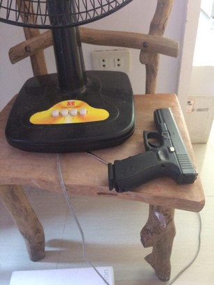 glock 17 g4 and magazine on top of wooden chair beside electric fan side view