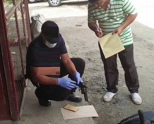 hand gun being retrieved by a police from crime scene