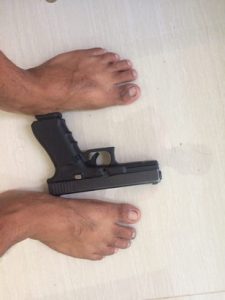 glock 17 on the floor in between mans feet side view