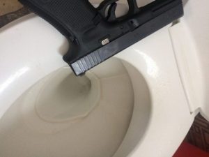 glock 17 on top of a comfort room basin